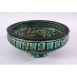 AN EARLY PERSIAN TURQUOISE POTTERY BOWL, decorated with floral motif, 19cm (af)