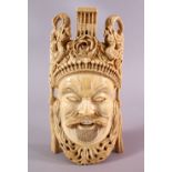 A FINELY CARVED 19TH CENTURY CHINESE IVORY MASK - depicting a warrior, with headdress, dragons and