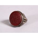 A 19TH CENTURY ISLAMIC INTAGLIO STYLE CALLIGRAPHIC SILVER RING, with an inset hard stone carved with