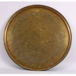A LARGE 19TH CENTURY EGYPTIAN BRASS CHARGER / TRAY, with carved bands of calligraphy and motif