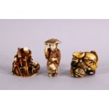 THREE JAPANESE MEIJI PERIOD CARVED IVORY NETSUKE - One depicting a lady holding her hat on, inset