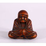 A JAPANESE MEIJI PERIOD CARVED BOXWOOD NETSUKE OF A SEATED ARHAT - in a seated position ,