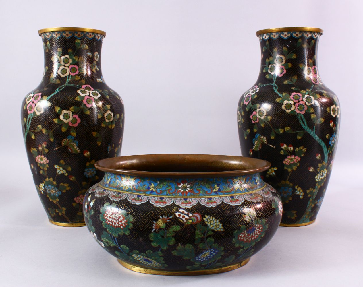 A 19TH / 20TH CENTURY CHINESE CLOISONNE TRIO, consisting of a pair of vases and a planter, decorated