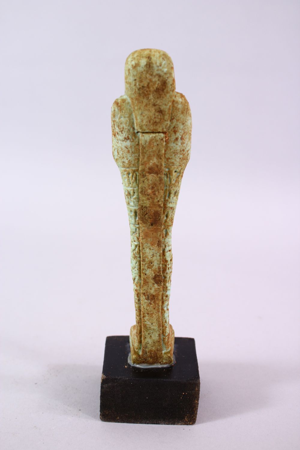 A CARVED POTTERY EGYPTIAN SHABTI, stoof upon a wooden base, 19cm high. - Image 4 of 4