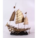 A 19TH CENTURY CHINESE SILVERED MODEL OF A JUNK / SHIP , upon a wave formed carved wooden base, 32cm