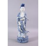 A CHINESE 19TH / 20TH CENTURY BLUE & WHITE PORCELAIN FIGURE OF GUANYIN, stood holding a vessel, upon