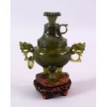 A CHINESE CARVED JADE LIDDED POT & COVER, with twin dragon head handles, on three feet, with a