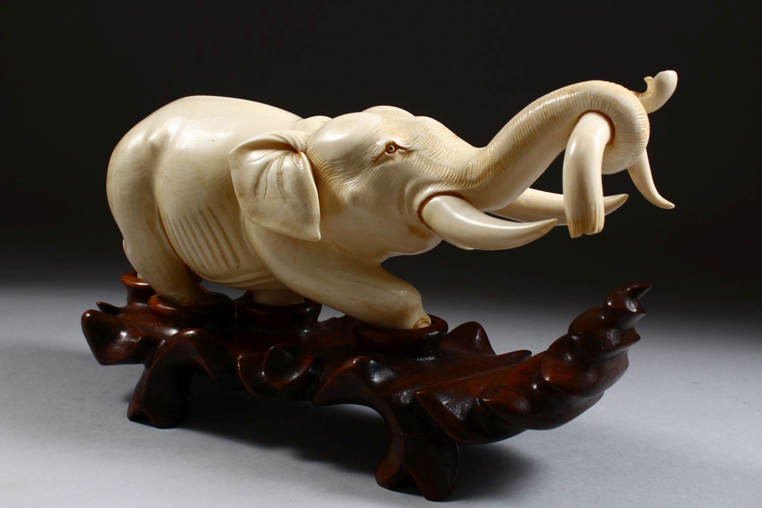 A 19TH CENTURY CHINESE CARVED IVORY FIGURE OF AN ELEPHANT, the elephant holding on to the horn of - Image 4 of 9