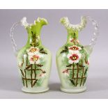 A 19TH CENTURY PAIR OF OPALINE GLASS MOULDED JUGS, with a moulded rim and floral painted decor, 25cm