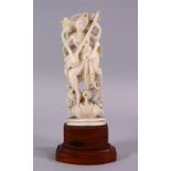 A 19TH CENTURY INDIAN CARVED IVORY FIGURE OF A MULTI ARM DEITY, playing a musical instrument, on a