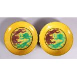 A PAIR OF CHINESE YELLOW GROUND INCISED DRAGON SAUCERS, with green and brown dragons upon yellow