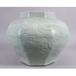 A LARGE CHINESE MING STYLE CELADON GLAZED OCTACONAL JAR, carved with dragons amongst waves, 29cm x