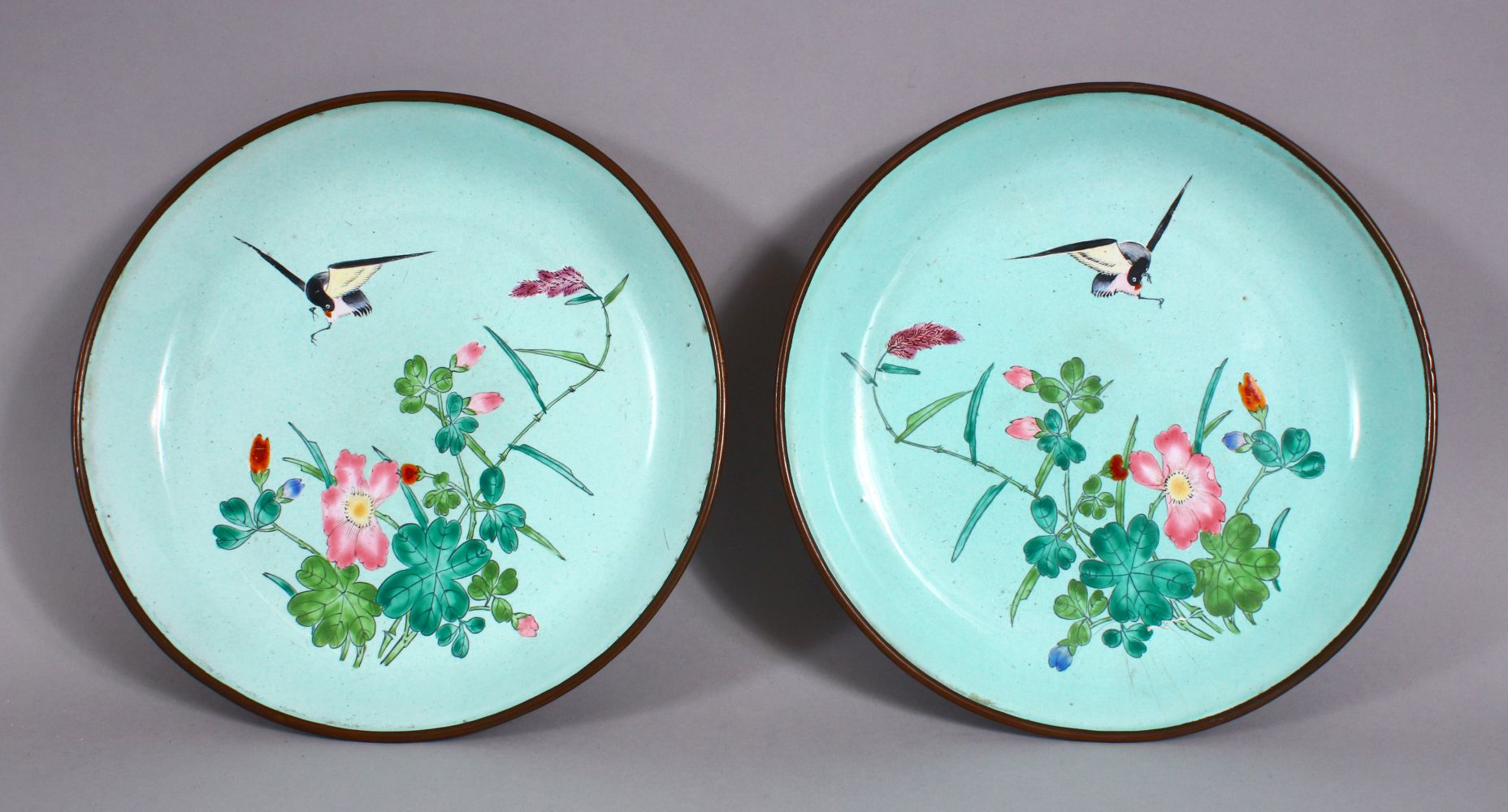 A PAIR OF 19TH / 20TH CENTURY CHINESE ENAMEL SAUCER DISHES, each decorated witih scenes of a bird in