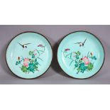 A PAIR OF 19TH / 20TH CENTURY CHINESE ENAMEL SAUCER DISHES, each decorated witih scenes of a bird in