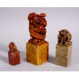 THREE CHINESE CARVED SOAPSTONE SEALS, each carved with dragons and lion dogs, two bases carved