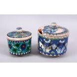 TWO EARLY TURKISH POTTERY LIDDED JARS, both decorated with floral design, 12cm & 10cm diameter.
