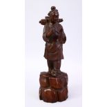 A JAPANESE MEIJI PERIOD CARVED WOODEN OKIMONO OF A TRAVELLING BOY, the boy wearing his back pack and