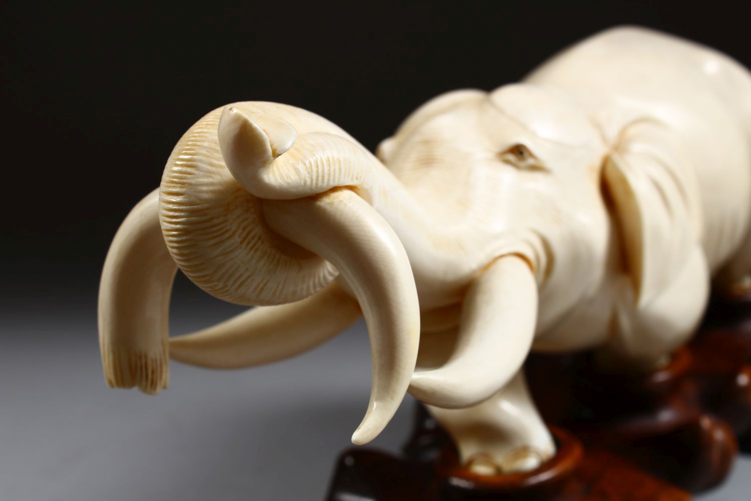 A 19TH CENTURY CHINESE CARVED IVORY FIGURE OF AN ELEPHANT, the elephant holding on to the horn of - Image 8 of 9