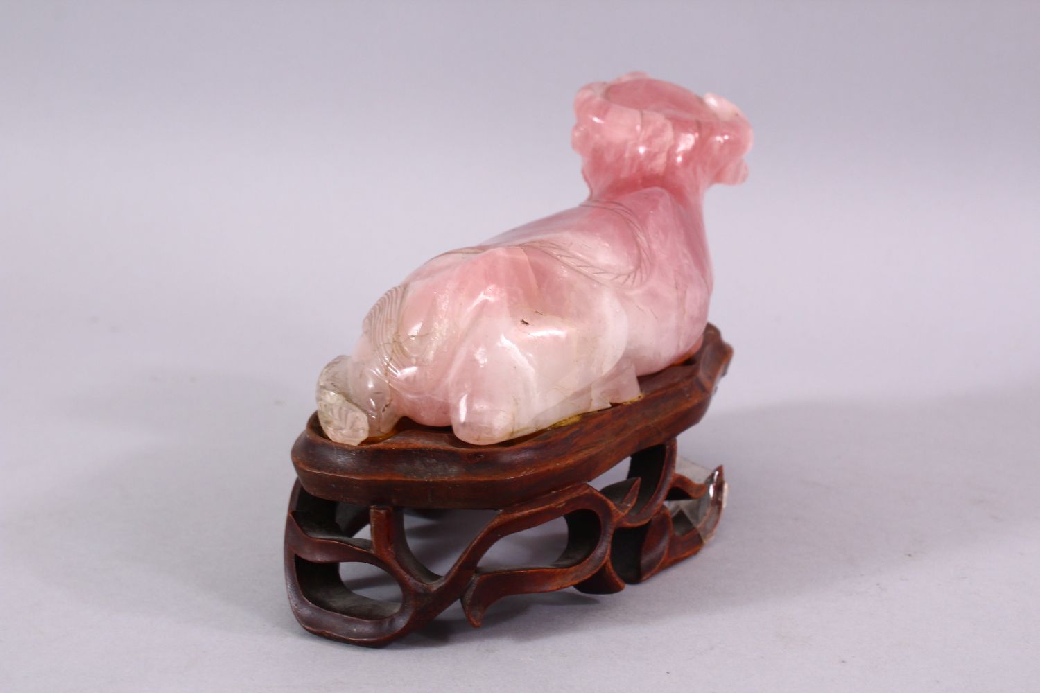 A CHINESE CARVED ROSE QUARTZ FIGURE OF A RECUMBENT OXEN, in a led position upon a carved hardwood - Image 4 of 5