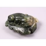 A CHINESE CARVED JADE BELT BUCKLE / DECORATION OF A RECUMBENT KYLIN, upon a leaf, 6.5cm.