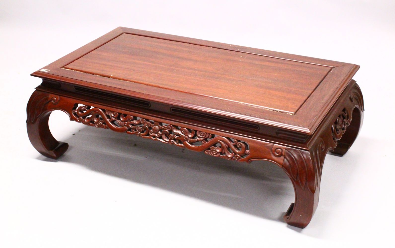 AN EARLY 20TH CENTURY CHINESE CARVED HARDWOOD COFFEE TABLE, with a carved frieze and curving legs,
