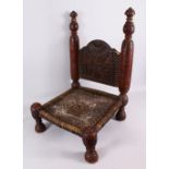 AN AFRICAN CARVED WOODEN CHAIR - with a woven seat and carved back, 72cm h x 48cm wide x 46cm