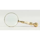 A MAGNIFYING GLASS WITH MOTHER-OF-PEARL AND GILT HANDLE.