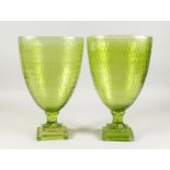 A PAIR OF LARGE GREEN TINTED PEDESTAL VASES on square bases. 14.5ins high.