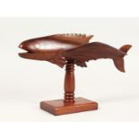 A PITCAIRN ISLAND CARVED WOOD FLYING FISH ON STAND, signed WILES WARREN. 12ins long.