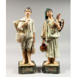 A PAIR OF 19TH CENTURY MAJOLICA GLAZED POTTERY FIGURES of a boy and girl water carrier. 13.5ins