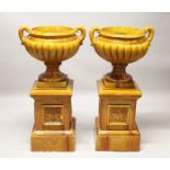 A GOOD LARGE PAIR OF LATE 19TH CENTURY TREACLE GLAZED POTTERY TWIN-HANDLED URNS of classical