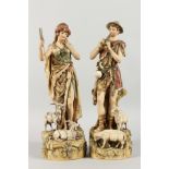 A PAIR OF ROYAL DUX PORCELAIN FIGURES depicting a shepherd playing pipes and a shepherdess. 15ins