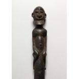 A TRIBAL CARVED WOOD SCEPTRE, with figural top. 19.75ins long.
