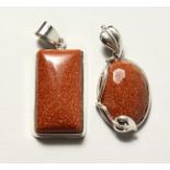 TWO SILVER AND GOLD STONE PENDANTS.