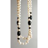 A LONG PEARL AND BLACK JET NECKLACE.