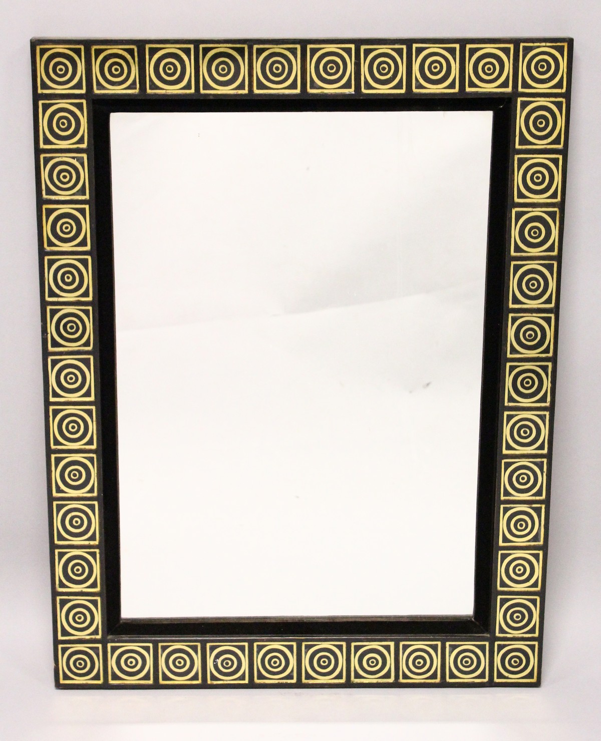 A RECTANGULAR WALL MIRROR, with black and gilt decorated frame. 2ft 9ins x 2ft 1ins.