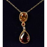 A 9CT GOLD, CITRINE AND GARNET PENDANT AND CHAIN.