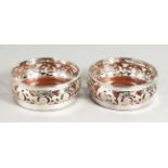 A PAIR OF SILVER PLATED CIRCULAR PIERCED WINE COASTERS.