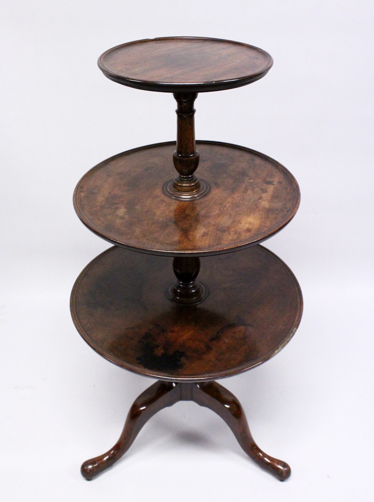 A GEORGE III MAHOGANY THREE-TIER DUMB WAITER, with central turned support, tripod base ending in pad
