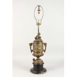 A 19TH CENTURY CUPID TWO-HANDLED URN LAMP on a circular wooden base. 22ins high.