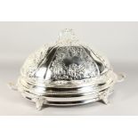 A GOOD LARGE TWO-HANDLED SERVING DISH AND COVER, repousse with scrolls and flowers, the base with