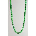 A SUPERB LONG STRING OF CAVED JADE BEADS with gold and diamond clasp.