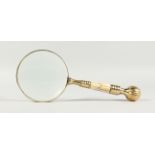 A MAGNIFYING GLASS WITH MOTHER-OF-PEARL AND GILT HANDLE.
