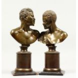 A GOOD PAIR OF SMALL BRONZE BUSTS of an African man and woman, on circular bronze bases. 11ins and