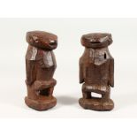 AN UNUSUAL PAIR OF TRIBAL CARVED WOOD STANDING FIGURES. 8ins high.