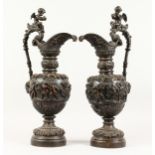 A SUPERB PAIR OF LARGE BRONZE ITALIAN CLASSICAL EWERS, with a band of cupids, rams masks and