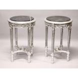A PAIR OF ROUND SILVERED WOOD TABLES with marble tops.