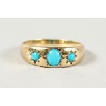 A 9CT YELLOW GOLD THREE-STONE TURQUOISE RING.
