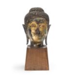 A Thai gilt-bronze and lacquer buddha head on stand