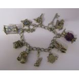 Silver charm bracelet with assorted silver and white metal charms L 7" total weight 1.60 ozt